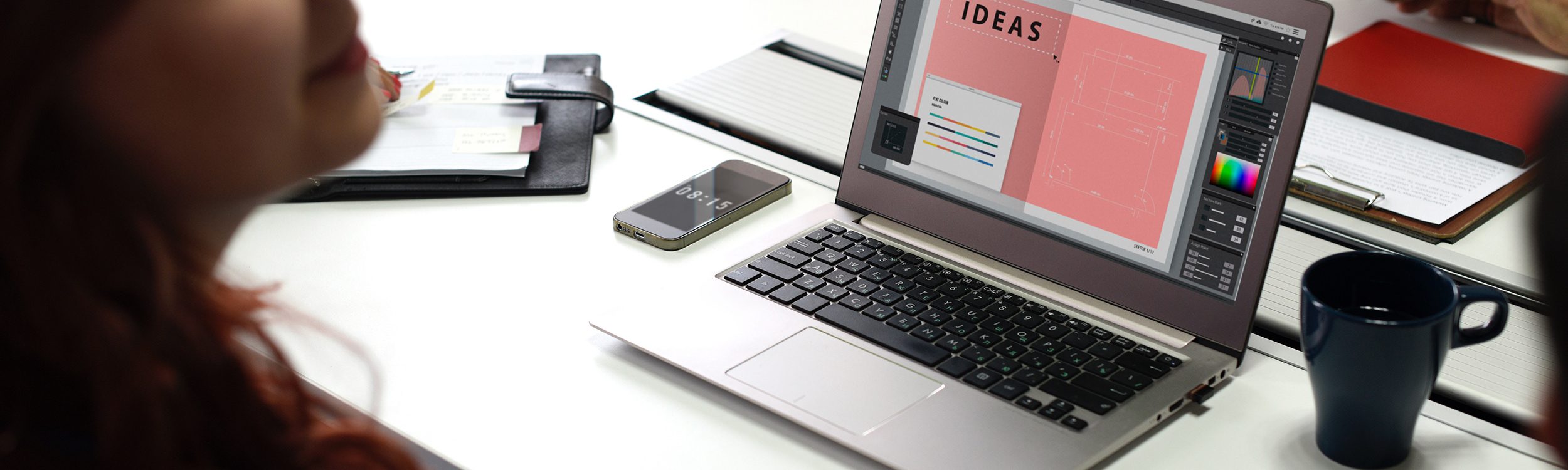 Laptop computer placed next to a computer and cup of coffee